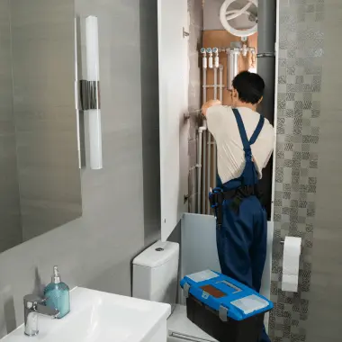 Plumber repairing pipes in a bathroom